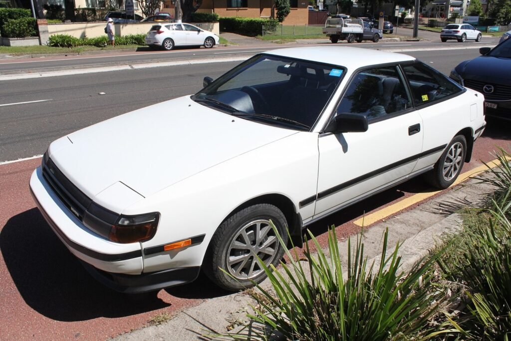 White fourth-generation Toyota Celica liftback parked at the kerb of a city street